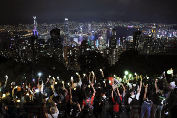 Demonstrators hold up the mobile phone lights as they form a human chain at the Peak, a tourist spot in Hong Kong, Friday, Sept. 13, 2019. Protest-related activities are expected to continue Friday, when Chinese celebrate the Mid-Autumn Festival with lanterns and mooncakes. Police banned a planned major march in central Hong Kong on Sunday, but many protesters have said they will turn up anyway. (AP Photo/Kin Cheung)