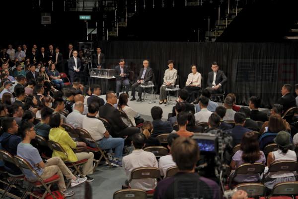 Hong Kong Chief Executive Carrie Lam, center on the stage, attends a community dialogue at the Queen Elizabeth Stadium in Hong Kong, Thursday, Sept. 26, 2019. Scores of protesters chanted slogans outside the venue as Lam began the town hall session Thursday aimed at cooling down months of demonstrations for greater democracy in the semi-autonomous Chinese territory. (AP Photo/Kin Cheung)