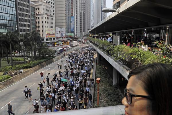 Protesters march during a flash mob protest in Hong Kong, on Friday, Oct. 11, 2019. Hundreds of masked protesters gathered at Chater Garden in central Hong Kong on Friday to rally against police brutality and show their support for students who have been arrested during the ongoing anti-government demonstrations. (AP Photo/Kin Cheung)