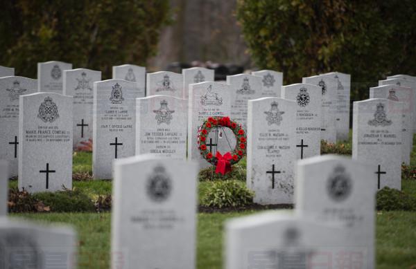 A wreath stands in front of a tombstone at the National Military Cemetery at Beechwood Cemetery in Ottawa on the day before Remembrance Day, Sunday, Nov. 10, 2019. THE CANADIAN PRESS/Justin Tang