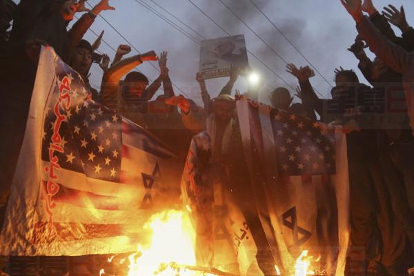 Pakistani Shiite Muslims burn representations of Israeli and U.S. flags during a rally in protest of the recent U.S. attack in Iraq that killed Iranian Gen. Qassem Soleimani, outside the U.S. Consulate in Lahore, Pakistan, Tuesday, Jan. 7, 2020. (AP Photo/K.M. Chaudary)
