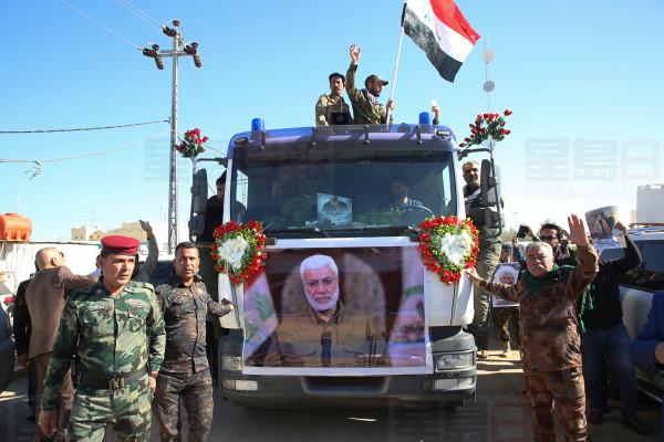 Mourners gather during a funeral procession for Abu Mahdi al-Muhandis, in the poster, deputy commander of Iran-backed militias in Basra, Iraq, Tuesday, Jan. 7, 2020. Thousands of people gathered in Basra on Tuesday to bid farewell to Abu Mahdi al-Muhandis, a senior Iraqi militia commander who was killed in a US airstrike on Friday. (AP Photo)