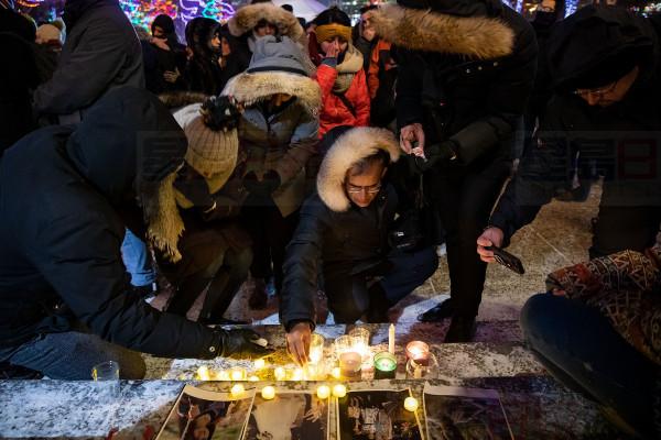 Mourners place candles and photographs during a vigil for those who were among the 176 people who were killed when Ukraine International Airlines Flight PS752 crashed after takeoff near Tehran, Iran, outside the Alberta Legislature Building in Edmonton on Wednesday, Jan. 8, 2020. THE CANADIAN PRESS/Codie McLachlan