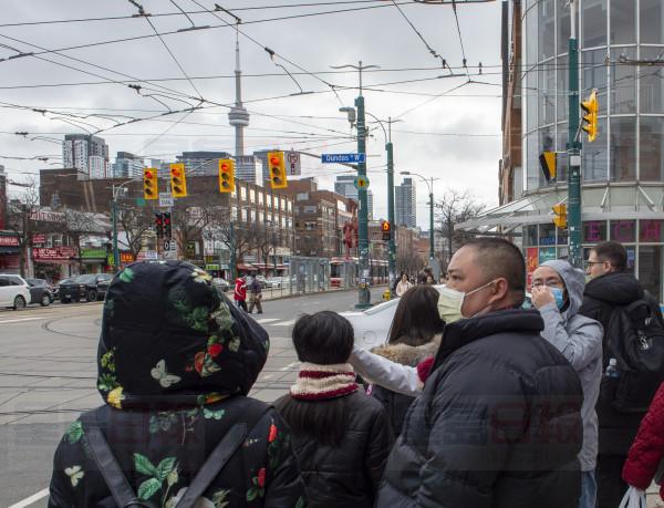 Pedestrians wear protective masks as they walk in Toronto on Monday, January 27, 2020. Canada's first presumptive case of the novel coronavirus has been officially confirmed, Ontario health officials said Monday as they announced the patient's wife has also contracted the illness. THE CANADIAN PRESS/Frank Gunn
