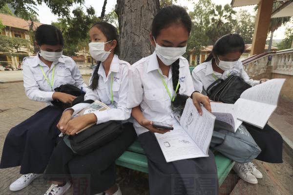 Students wear masks to avoid the contact of coronavirus before their morning class at a high school in Phnom Penh, Cambodia, Tuesday, Jan. 28, 2020. China on Tuesday reported 25 more deaths from a new viral disease, as the U.S. government prepared to fly Americans out of the city at the center of the outbreak. (AP Photo/Heng Sinith)
