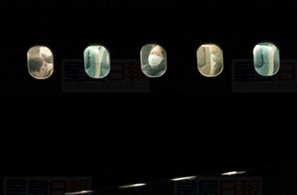 A passenger looks out of the window of a plane carrying Canadians back from Wuhan, China, on the tarmac at Vancouver International Airport, in Richmond, B.C., Thursday, Feb. 6, 2020. THE CANADIAN PRESS/Darryl Dyck