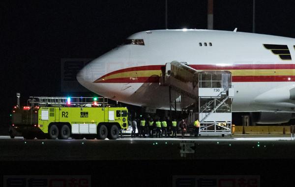Officials watch as passengers walk to a bus after exiting a plane chartered by the United States government carrying U.S. and Canadian citizens home from Wuhan, China, after arriving at Vancouver International Airport in Richmond, B.C., to refuel before continuing on to a U.S. Air Force Base, on Friday February 7, 2020. Canadians on the flight deplaned and boarded a smaller charter for a flight to CFB Trenton. THE CANADIAN PRESS/Darryl Dyck