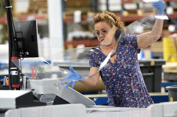 Nancy Diaz uses a Zund Cutter machine to fabricate face shields out of plastic sheeting at Vomela, a St. Paul manufacturer of signs for retail and sports, on Tuesday, April 14, 2020. Vomela has turned to producing face shields during the coronavirus (COVID-19) pandemic. (Scott Takushi / Pioneer Press)
