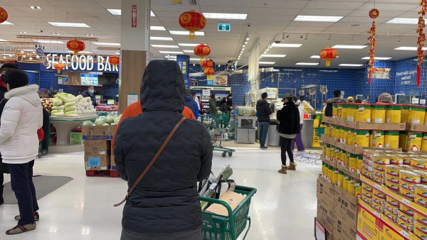 一大早超市就有很多人排隊買魚。   張譽攝