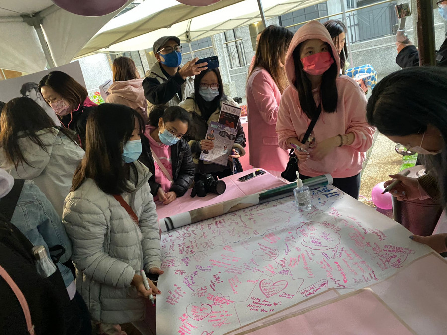 「神徒」冒著大雨都出席，並在《不可愛教主》横額背後簽名。星島記者攝