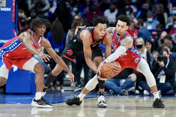 PHILADELPHIA, PA - NOVEMBER 11: Scottie Barnes #4 of the Toronto Raptors controls the ball against Tyrese Maxey #0 and Danny Green #14 of the Philadelphia 76ers in the first half at the Wells Fargo Center on November 11, 2021 in Philadelphia, Pennsylvania. NOTE TO USER: User expressly acknowledges and agrees that, by downloading and or using this photograph, User is consenting to the terms and conditions of the Getty Images License Agreement. (Photo by Mitchell Leff/Getty Images)