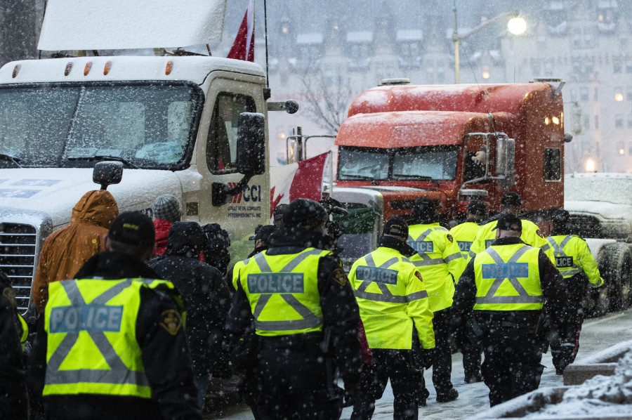 Police walk as heavy snow falls on the 21st day of a protest against COVID-19 measures that has grown into a broader anti-government protest, in Ottawa, on Thursday, Feb. 17, 2022. THE CANADIAN PRESS/Justin Tang