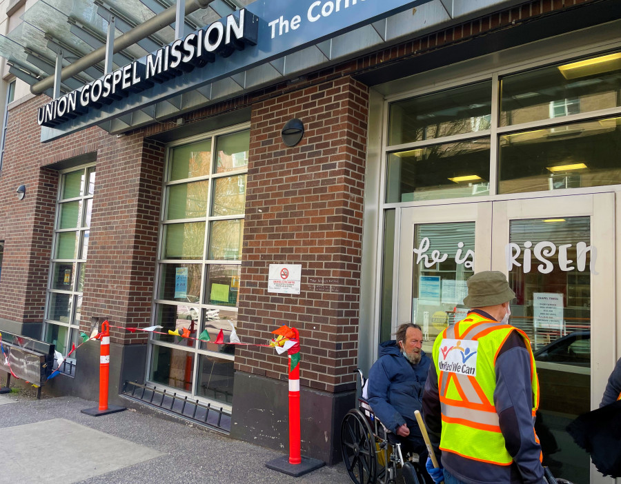 社區清潔人員幫忙收拾餐具,並協助領飯人士。星島記者王弘樹攝