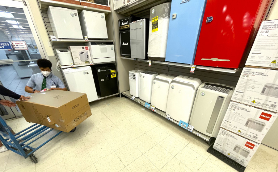 倫敦藥房的工作人員幫助顧客打包新購買的移動冷氣機。星島記者王弘樹攝