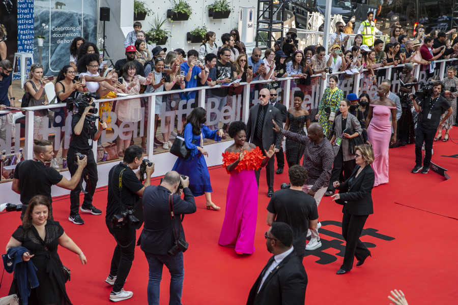 Viola Davis, centre, and Lashana Lynch, right in pink dress, walk the red carpet for "The Woman King" in a photo taken from the vantage point of the RBC Red Carpet Gallery, at the Toronto International Film Festival, in Toronto, Friday, Sept. 9, 2022. THE CANADIAN PRESS/Chris Young