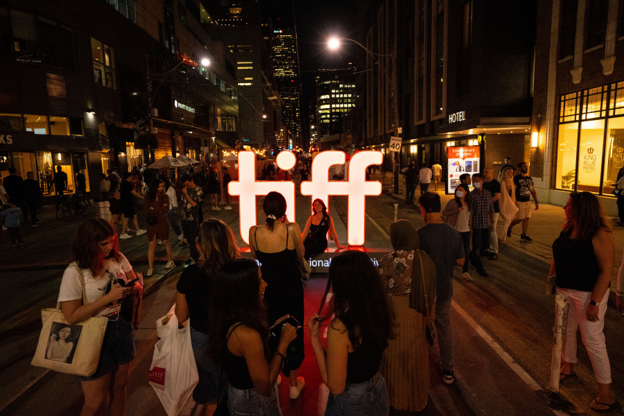 Visitors to the Toronto International Film Festival take photos in front of a TIFF sign in Toronto on Friday, September 9, 2022. THE CANADIAN PRESS/Alex Lupul