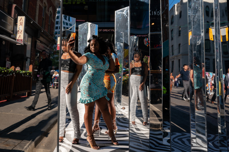 Visitors to the Toronto International Film Festival's kick off event take photos in a mirrored art installation in Toronto on Thursday, September 8, 2022. THE CANADIAN PRESS/Alex Lupul