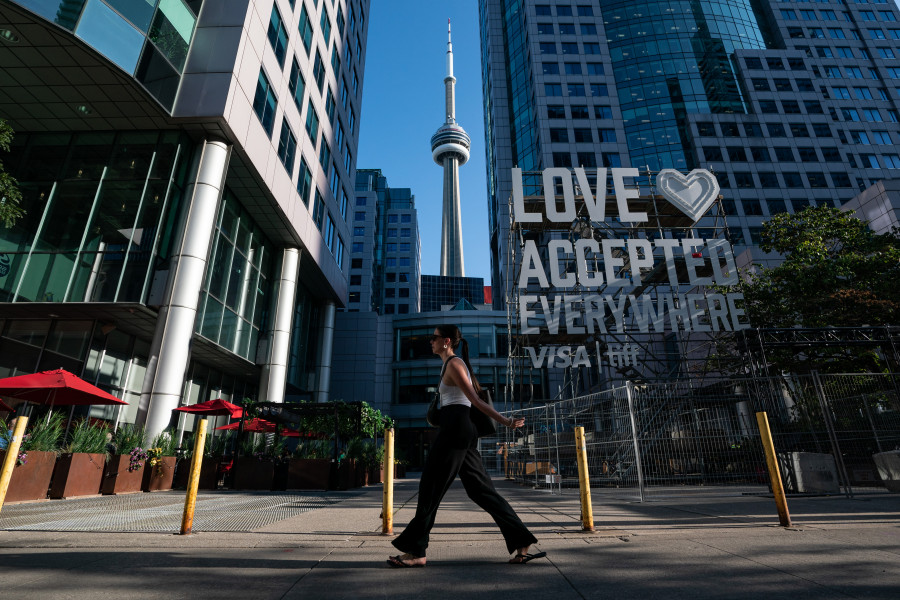 A visitor to the Toronto International Film Festival's kick off event walks past event signage in Toronto on Thursday, September 8, 2022. THE CANADIAN PRESS/Alex Lupul