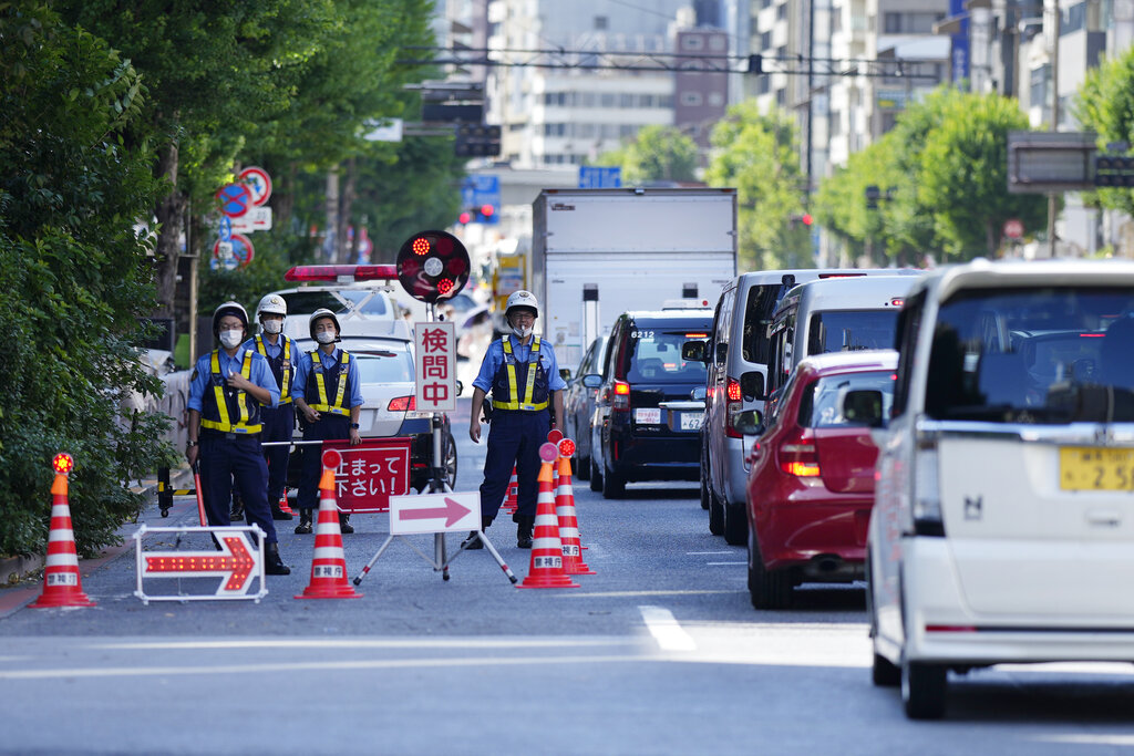 Police officers maintain a checkpoint as authorities have deployed extra officers to beef up security for the state funeral of former Prime Minister Shinzo Abe in Tokyo, Monday, Sept. 26, 2022. Japanese Prime Minister Fumio Kishida is hosting the controversial state-sponsored ceremony for the former leader Tuesday. (AP Photo/Hiro Komae)