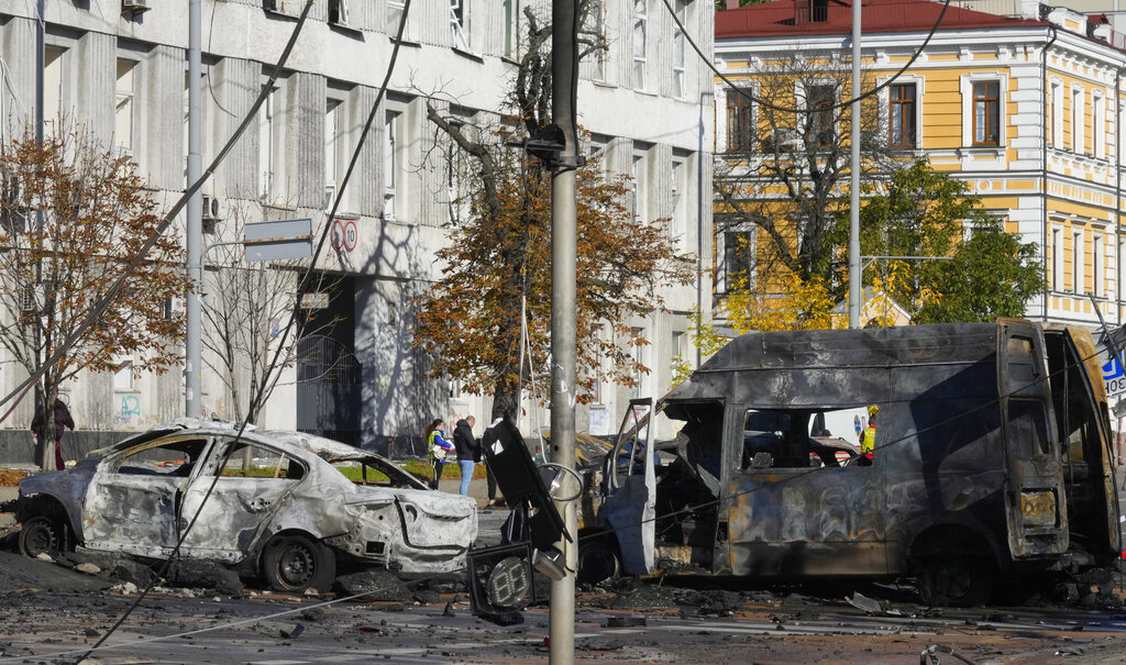 Damaged cars are seen at the scene of Russian shelling, in Kyiv, Ukraine, Monday, Oct. 10, 2022. Explosions on Monday rocked multiple cities across Ukraine, including missile strikes on the capital Kyiv for the first time in months. (AP Photo/Efrem Lukatsky)
