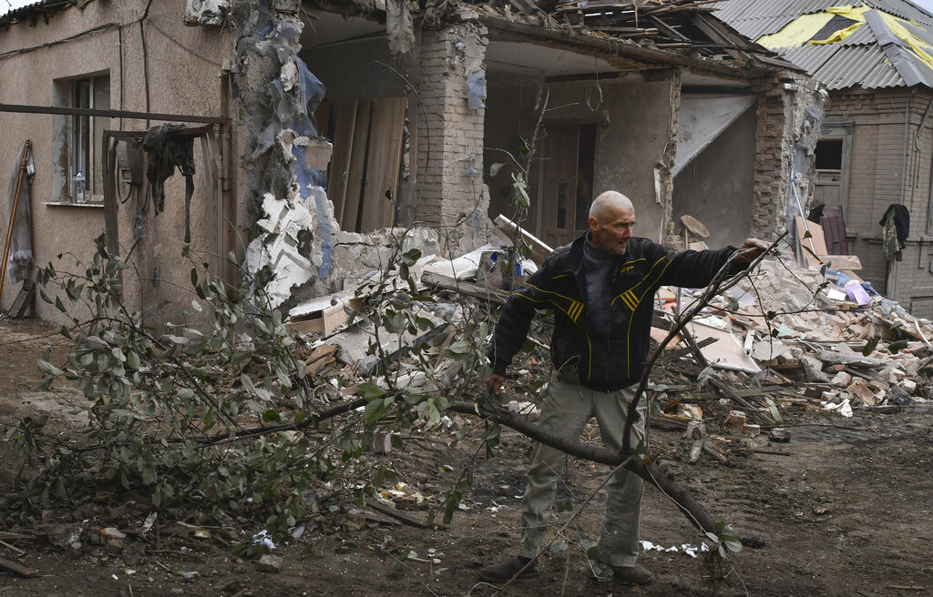 Petr Lisovoi, 61, works to remove debris from a damaged house after an overnight Russian shelling, in Sloviansk, Donetsk region, Ukraine, Monday, Oct. 10, 2022. Russia unleashed a lethal barrage of strikes against multiple Ukrainian cities Monday, smashing civilian targets including downtown Kyiv where at least eight people were killed. (AP Photo/Andriy Andriyenko)