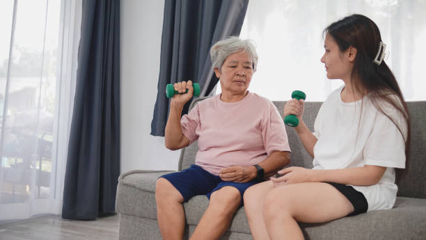 Home workout concept, Asian woman and Asian elderly woman exercising and lifting dumbbells.