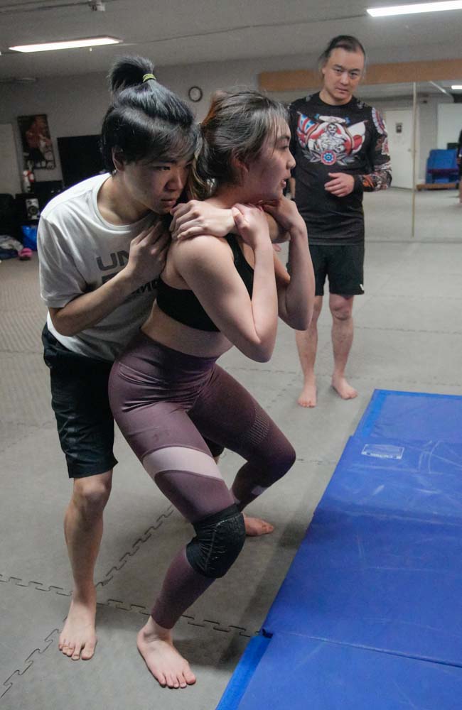 首先用雙手捉實對方前臂然後蹲低身體把重心降低;