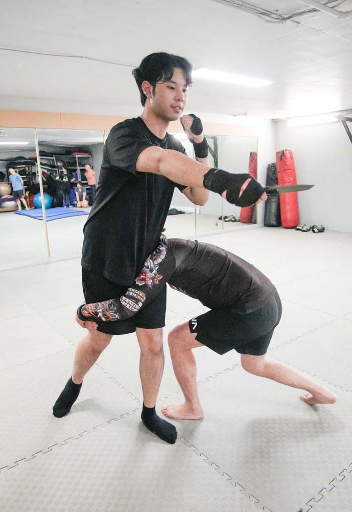 接著俯身用雙手攬著他的雙腿全力向前