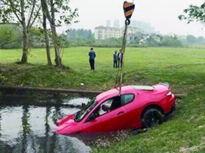 女司機低頭玩手機 百萬豪車衝入池塘報廢