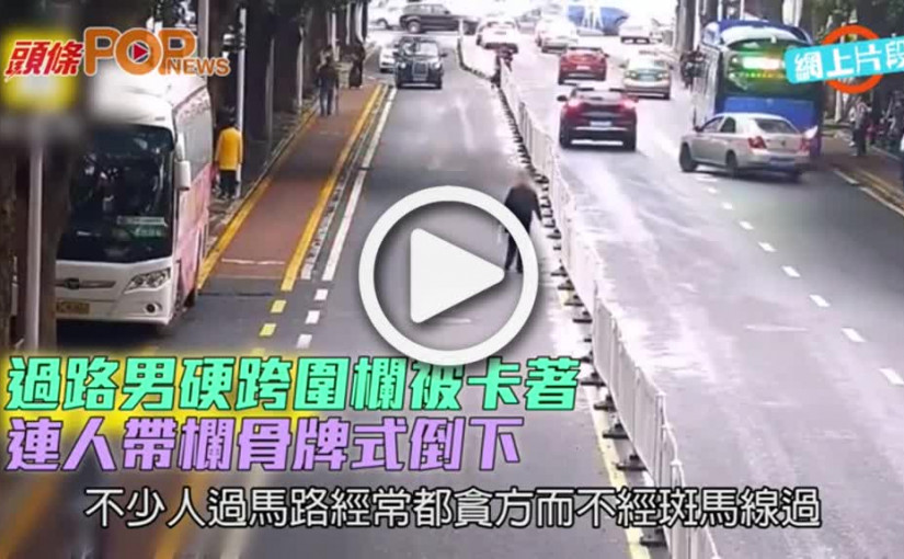 過路男硬跨圍欄被卡著  連人帶欄骨牌式倒下